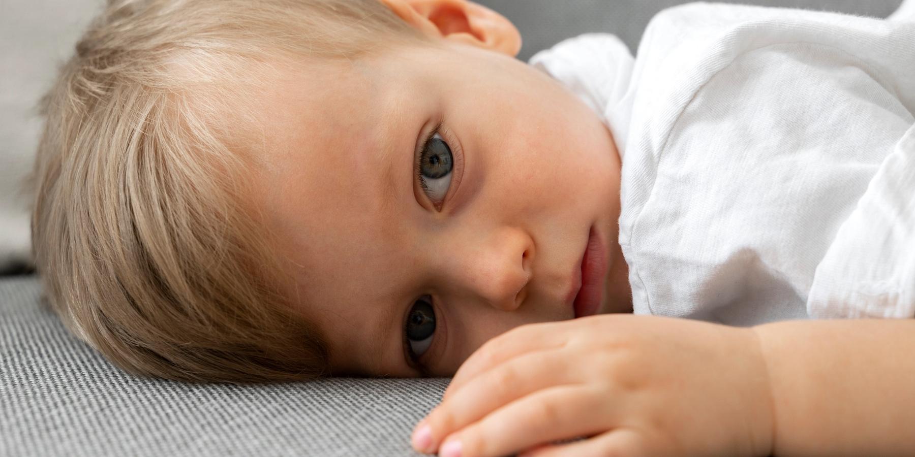 a baba nyitott szemmel fekszik a kanapén