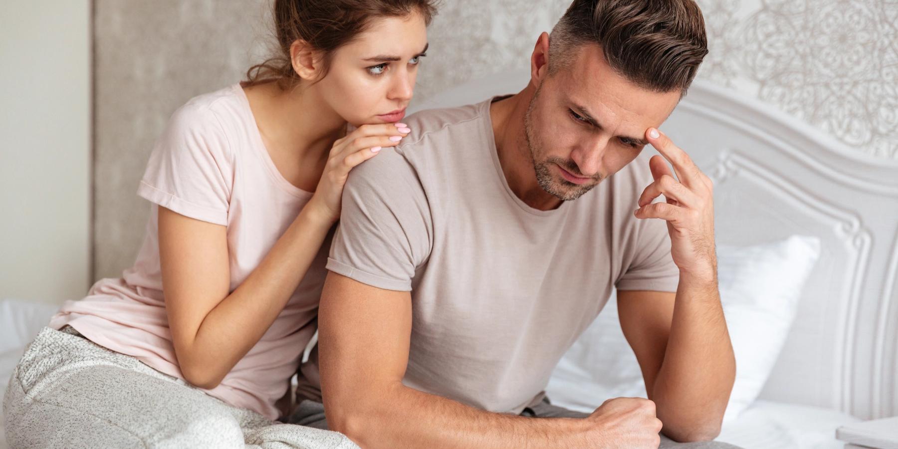 Fiatal pár gondterhelten ül az ágyon