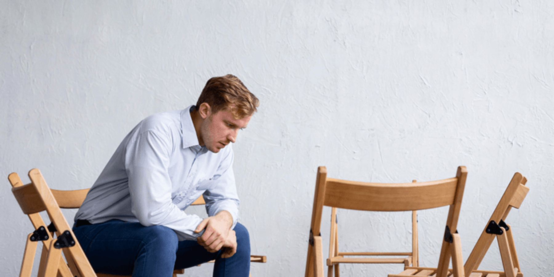 Férfi helytelenül ül a széken, és fájlalja a hátát