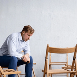 Férfi helytelenül ül a széken, és fájlalja a hátát