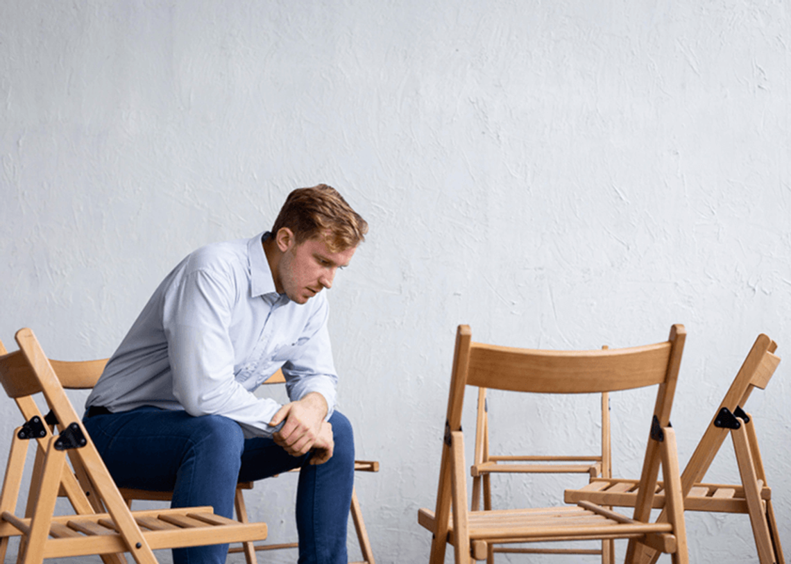 Férfi helytelenül ül a széken, és fájlalja a hátát