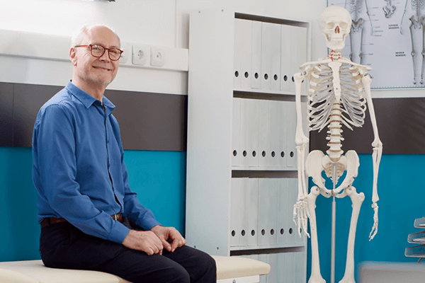 Elégedett férfi a váróteremben, mellette egy csontváz