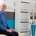 Elégedett férfi a váróteremben, mellette egy csontváz