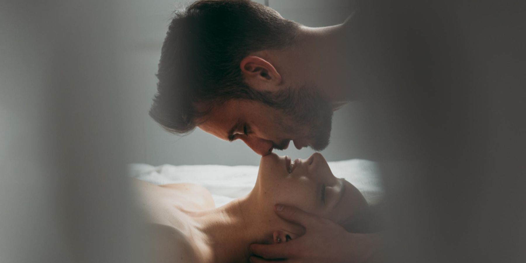 Férfi és nő intim környezetben, a férfi a nő hajába túr és megcsókolja