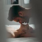 Férfi és nő intim környezetben, a férfi a nő hajába túr és megcsókolja