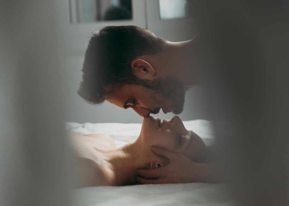 Férfi és nő intim környezetben, a férfi a nő hajába túr és megcsókolja