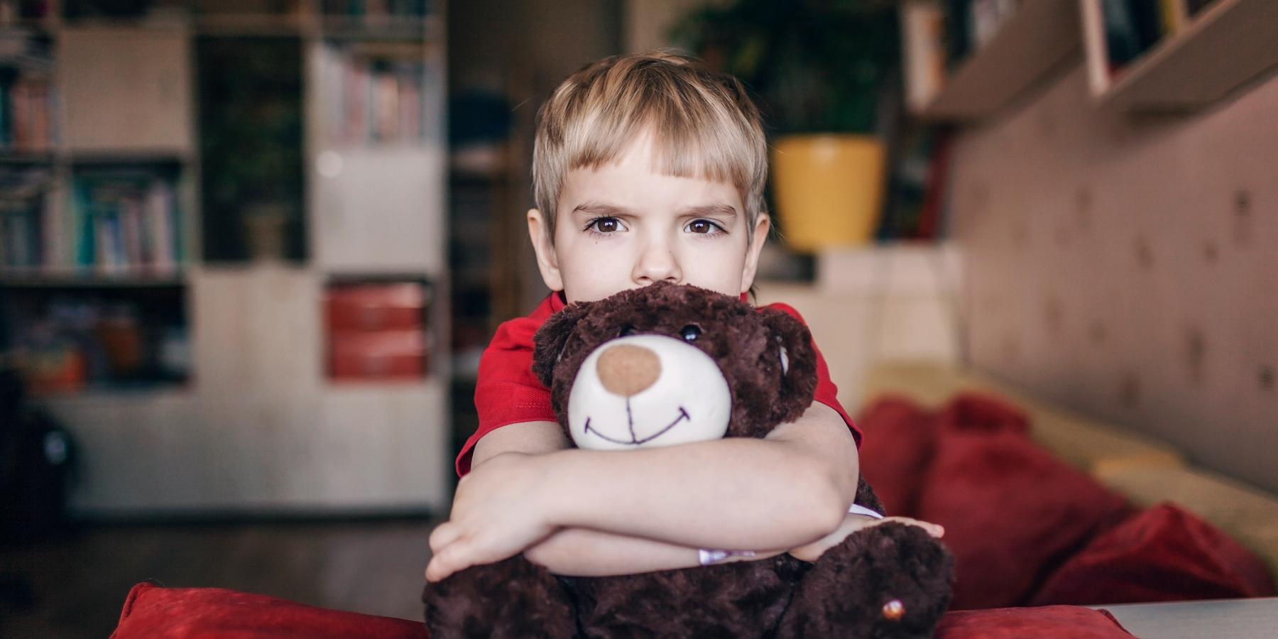 Kisfiú a maciját öleli