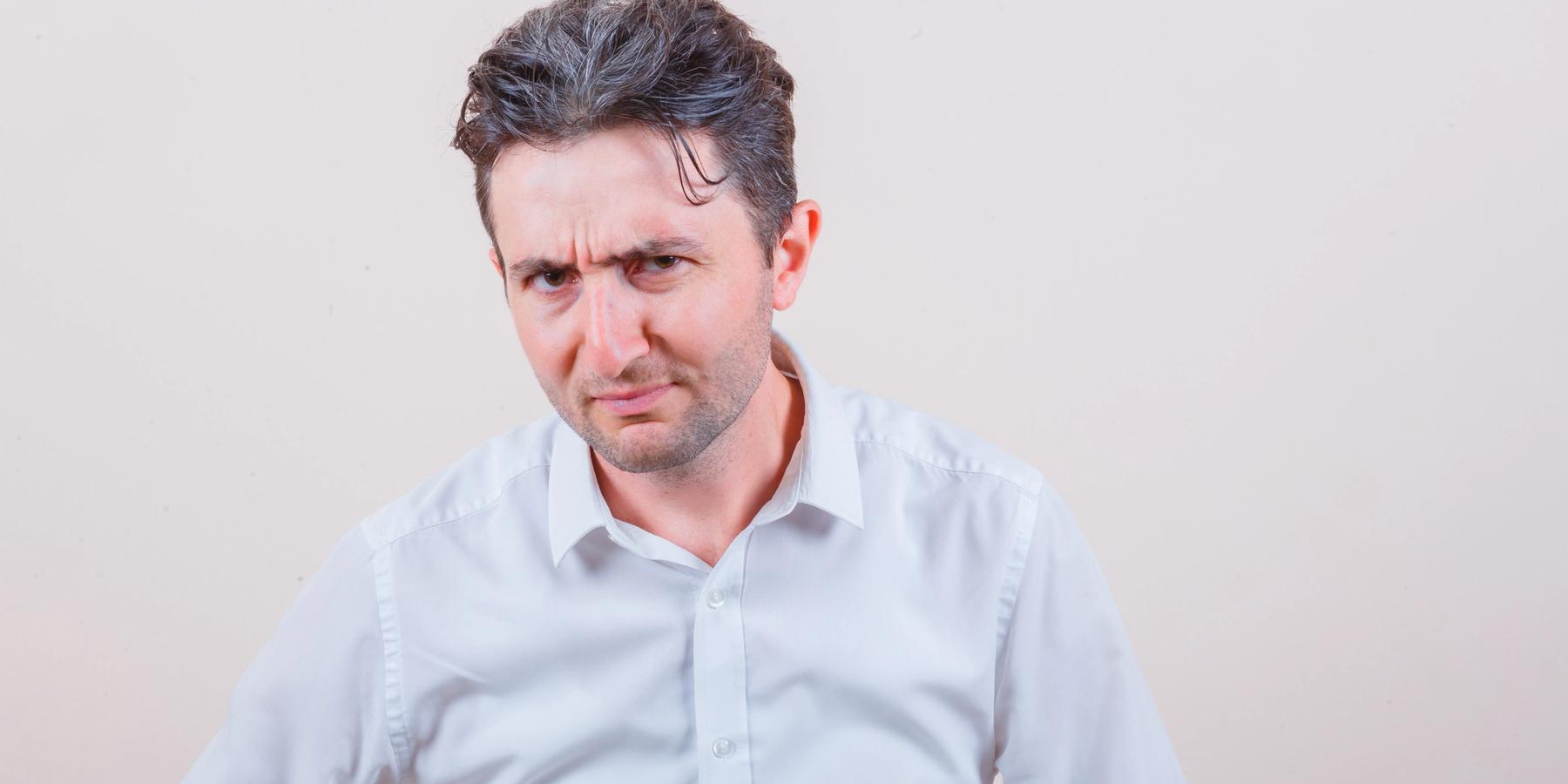 kamerába néző férfi ráncolja a homlokát