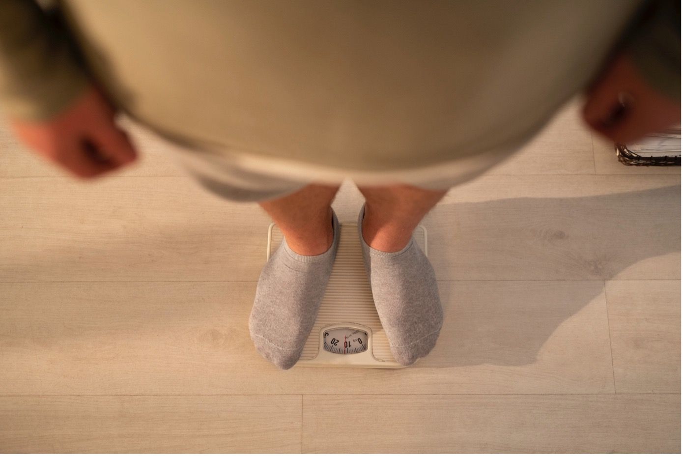 Túlsúlyos férfi áll a mérlegen