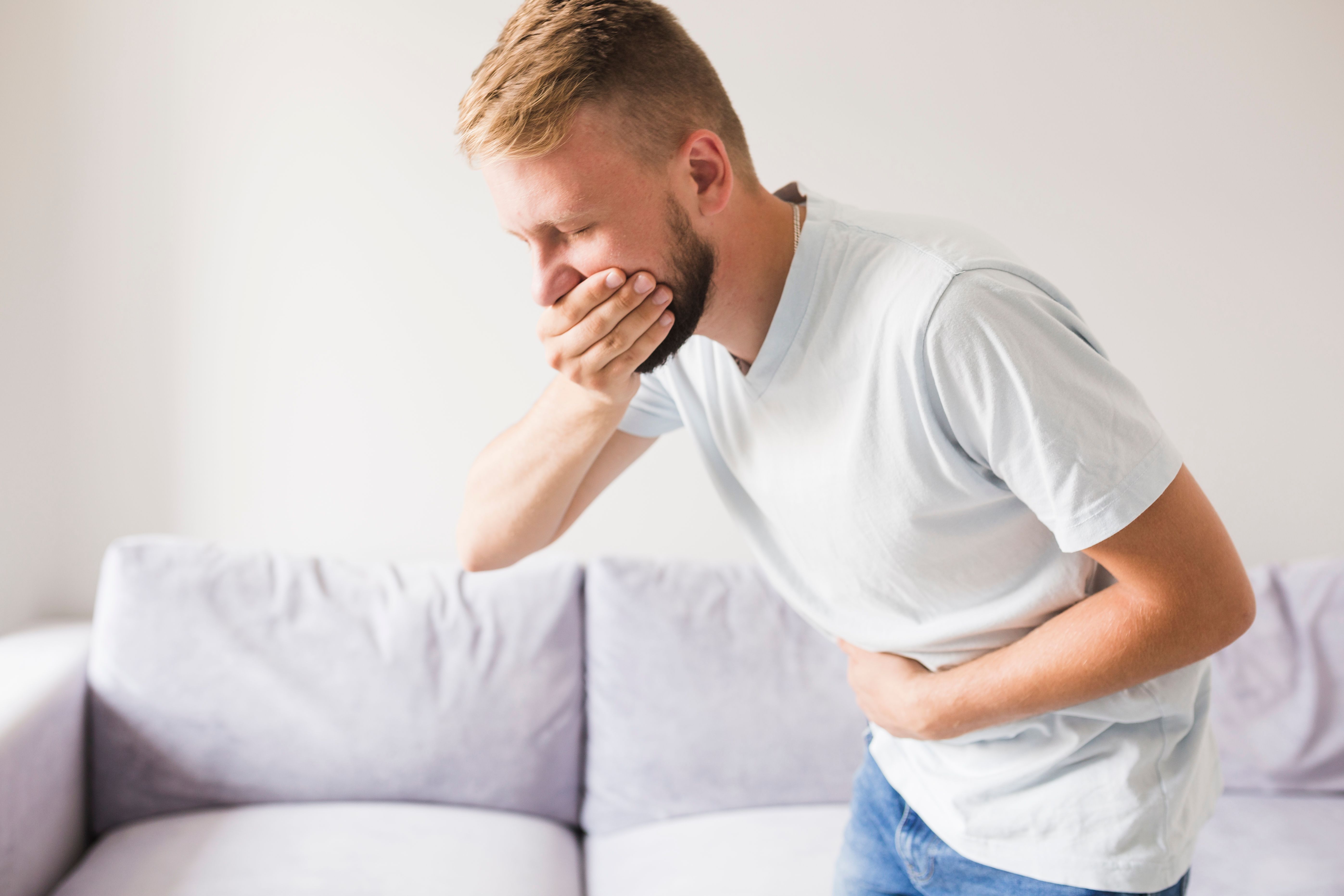 Hányástól szenvedő és száját bezáró férfi