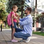 Felnőtt férfi a kislányát kíséri iskolába az első napon