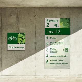 Bicycle and elevator sign on concrete wall
