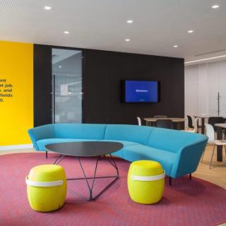 Dark colored acoustic panels with colorful furniture in open space