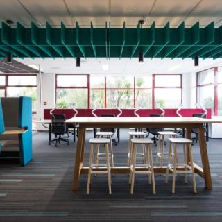 Green acoustic baffles over a conference table desk