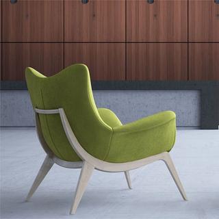 Side angle of one mid back winged chairs with green fabric