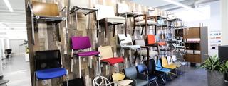 Various chairs in a variety of colors hanging on the showroom wall at CP Group