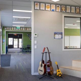 Schoolroom with guitars leaning against wall with acoustic wallcovering