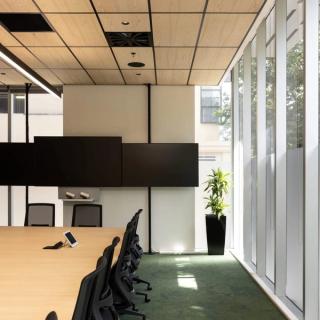 Conference room with wood acoustic ceiling tiles and conference table.
