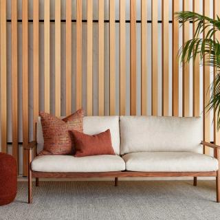 Vertical wood acoustic panels with white sofa and red pillows
