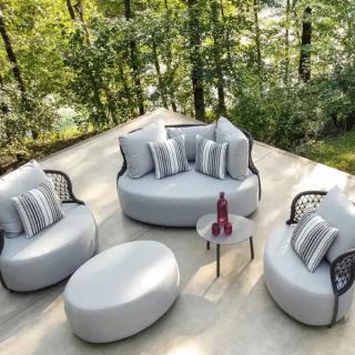 Gray and white lounge chairs on deck with forest in background with flyover view