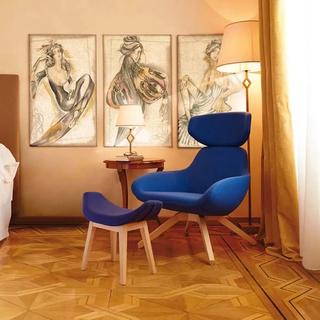 Dark blue armchair with foot rest in room with wood floor and framed paintings on wall