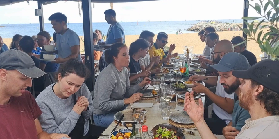 Corporate group enjoying a seaside lunch in Barcelona during a company offsite organised by Nessout