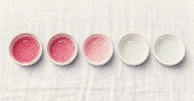 Row of five small dishes of water fading from deep pink to clear on linen