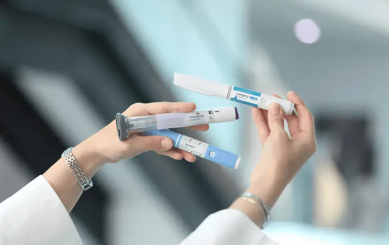 Person holding various injectable medication pens - Microdosing GLP 1