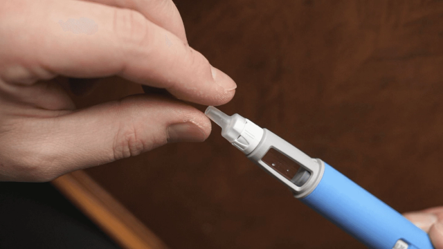 Person removing cap from medical pen - Who Should Not Take Semaglutide
