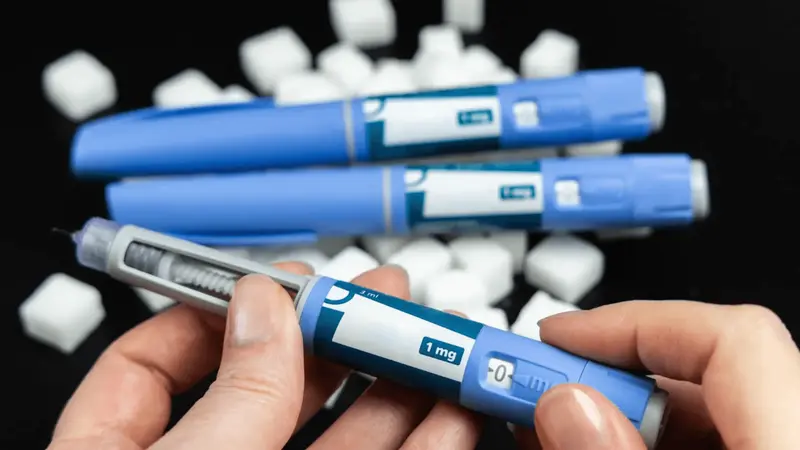 Person holding blue injectable medication pen - How to Track My Semaglutide Side Effects?