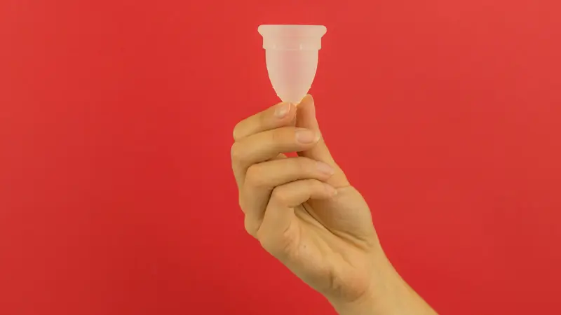 person holding menstrual cup - Does Tirzepatide Affect Your Period?