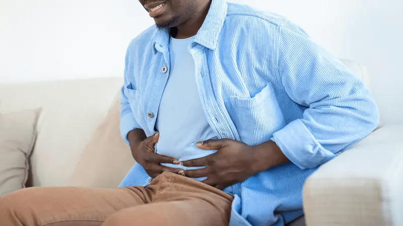 Man sitting and holding his stomach - Why Do GLP1 Cause Nausea