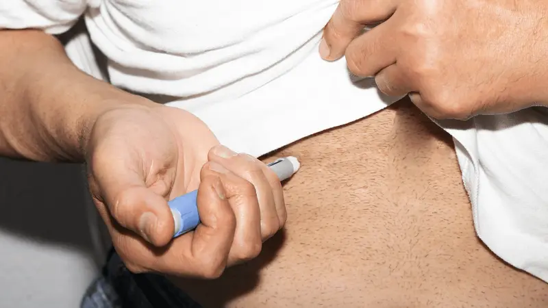Person injecting medication into their abdomen - How Old Do You Have to Be to Take Ozempic