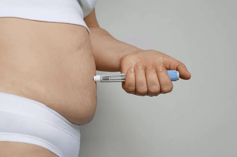 Person injecting medication into their abdomen -  How Much Protein Should I Eat on Semaglutide