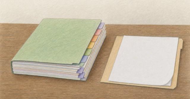 A thick tabbed paper file beside a thin folder holding one blank sheet on a wooden table