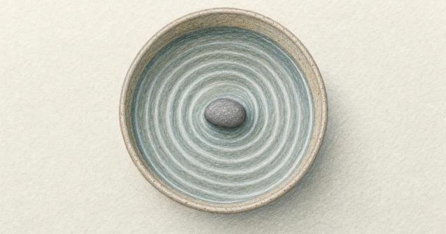 A pebble in a shallow bowl of water with ripples spreading outward to the rim