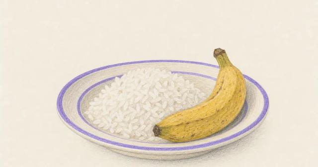 A plate of plain rice and a banana on a soft ceramic dish