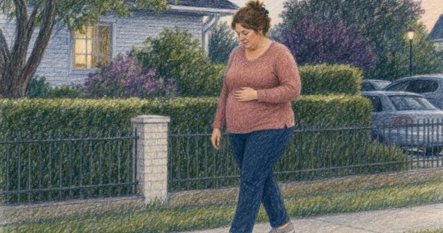Woman slowing mid-step on an evening neighborhood sidewalk, one hand resting on her stomach