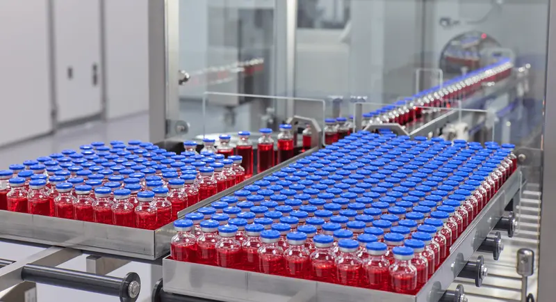 Vials of red liquid on conveyor - 503a vs 503b