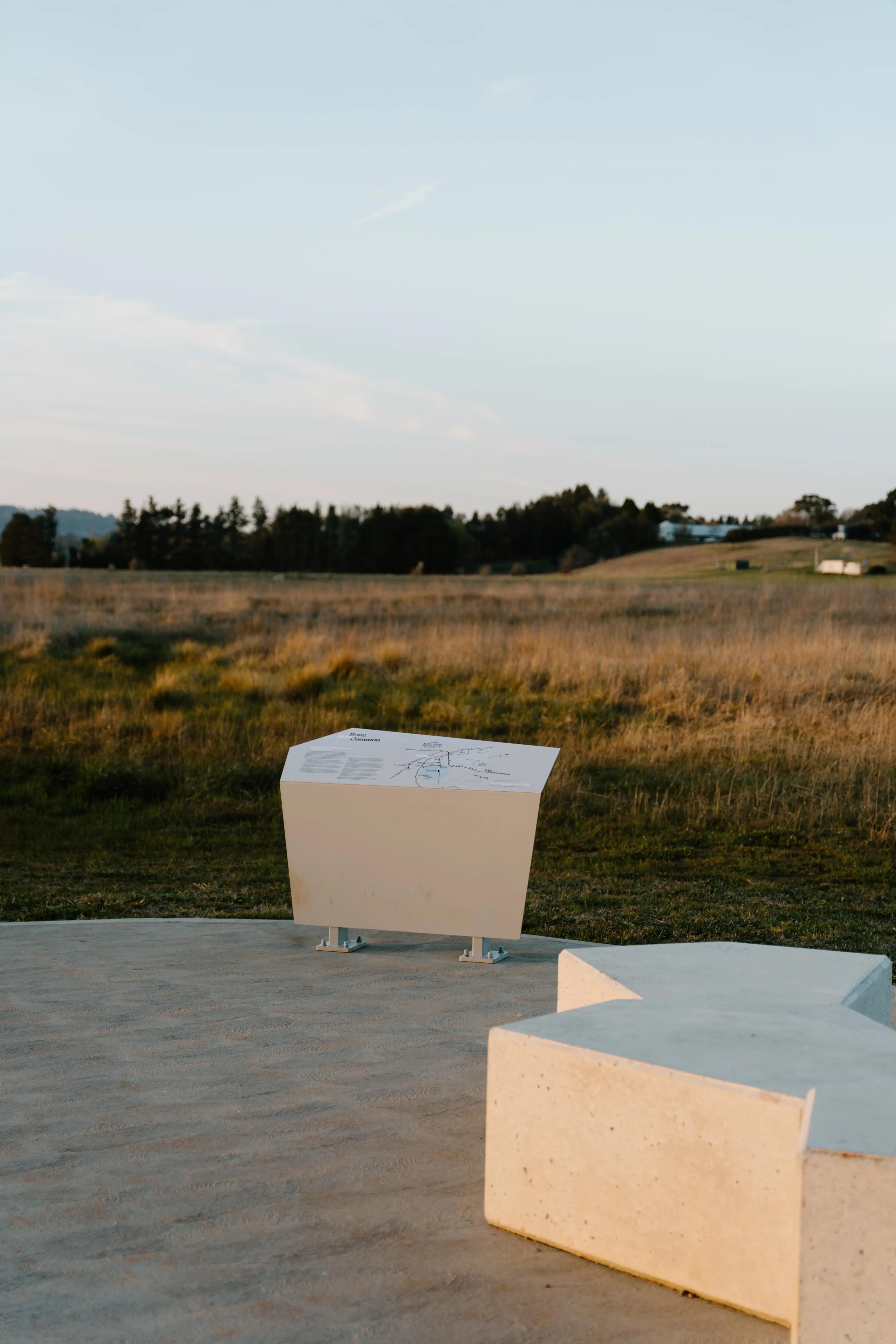 Bong Bong commons walking track and sign overlooking the neighbouring paddock