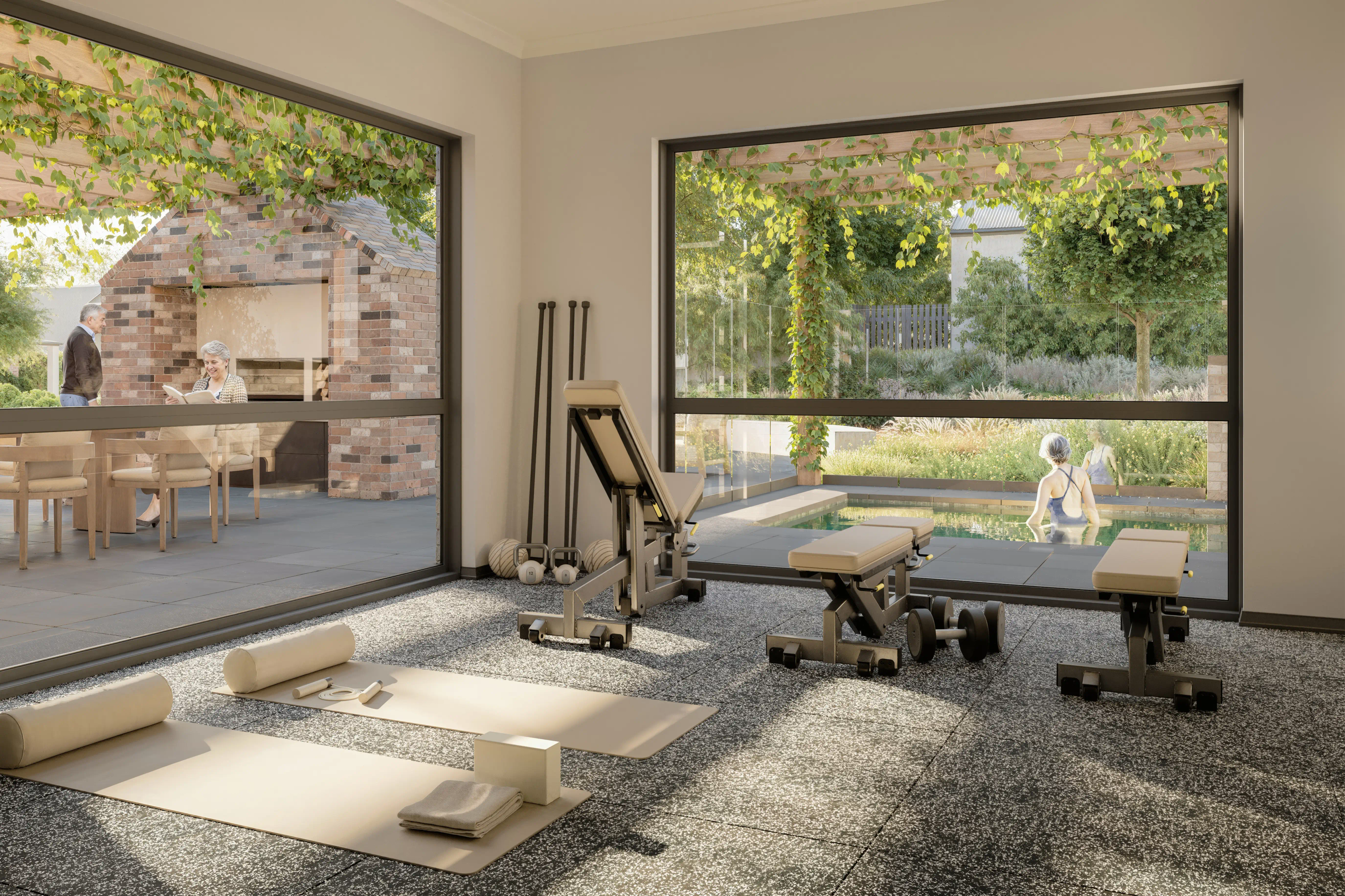 Gym room, with two yoga mats set up on the floor along with other gym equipment. Windows showing the communal outdoor dining space and a woman in the pool.
