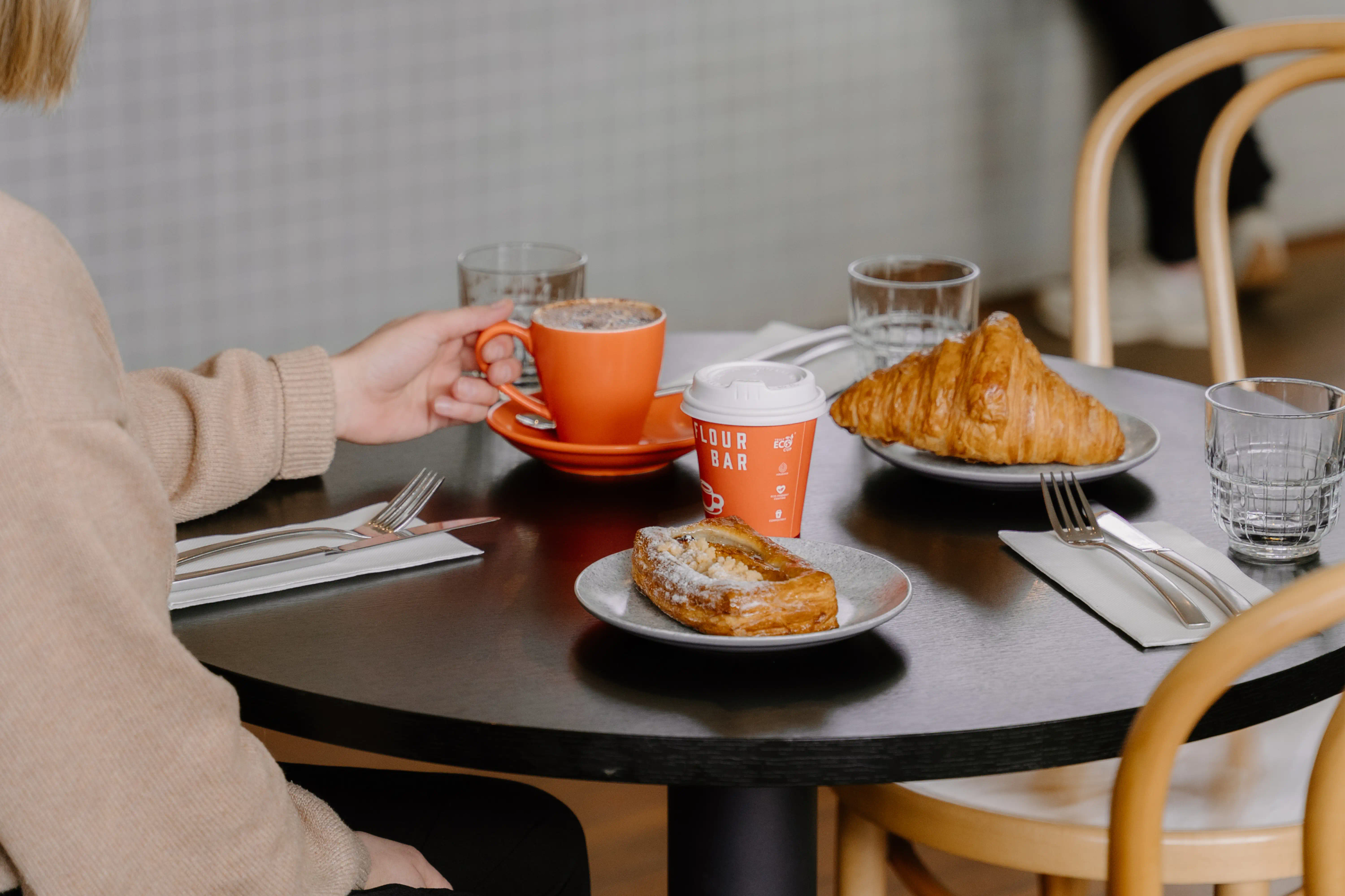 Flour bar cafe table with a coffee and two pastries. 