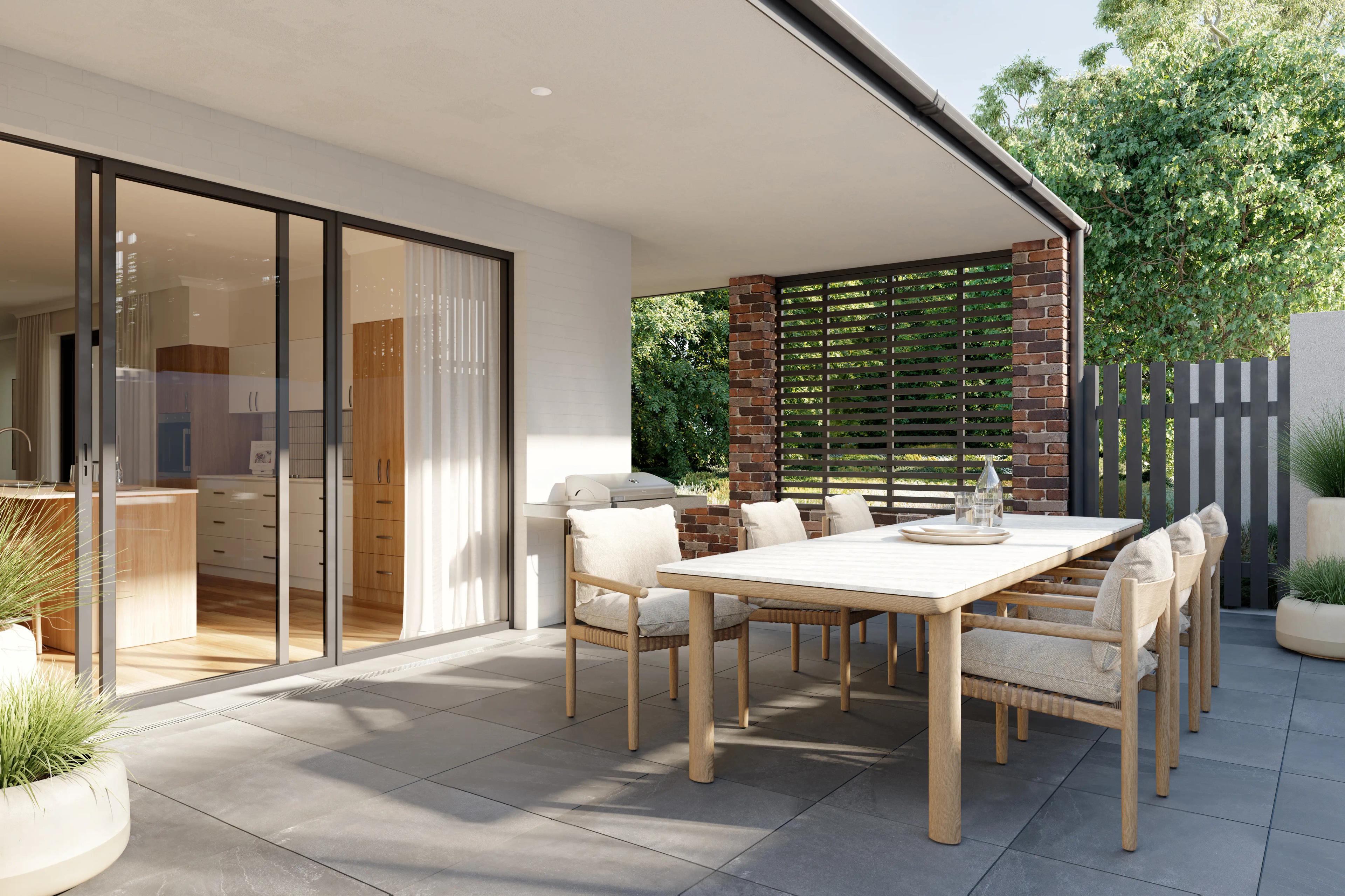 Villa's alfresco dining area with long dining table and 6 chairs, paved flowing surrounded by greenery. Door looks into the kitchen of the villa.