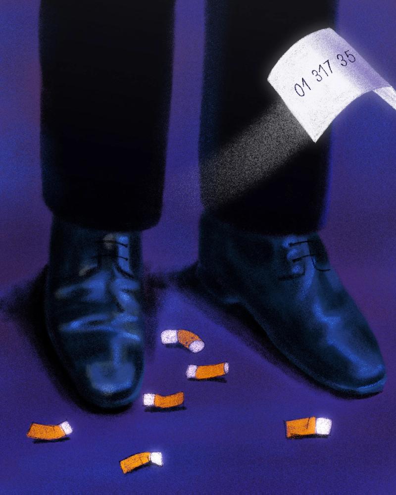 Feet with leather shoes and cigarettes on the floor. There is a fallen paper flying. 