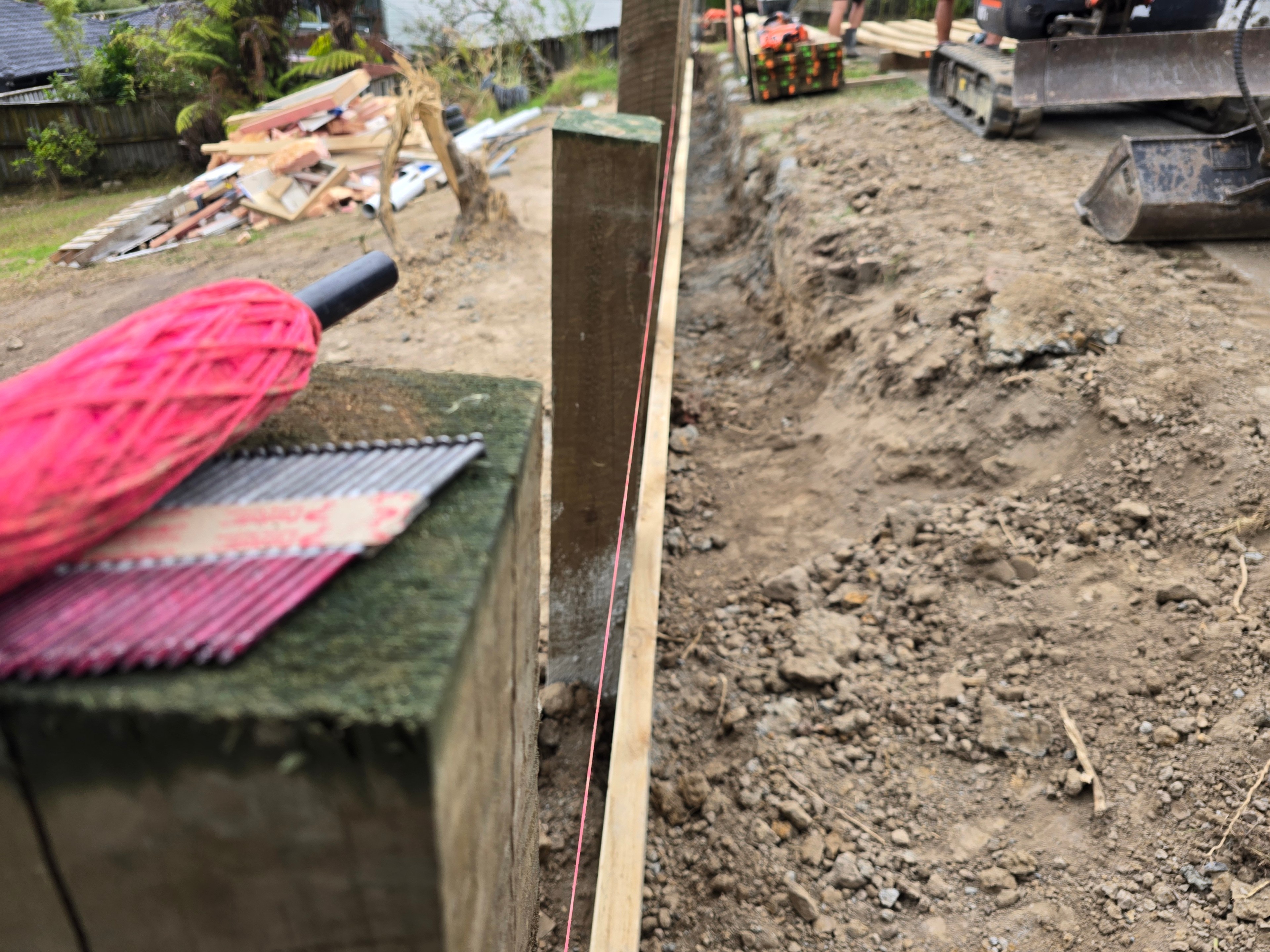 Setting out a retaining wall to a string line along a freshly cut batter