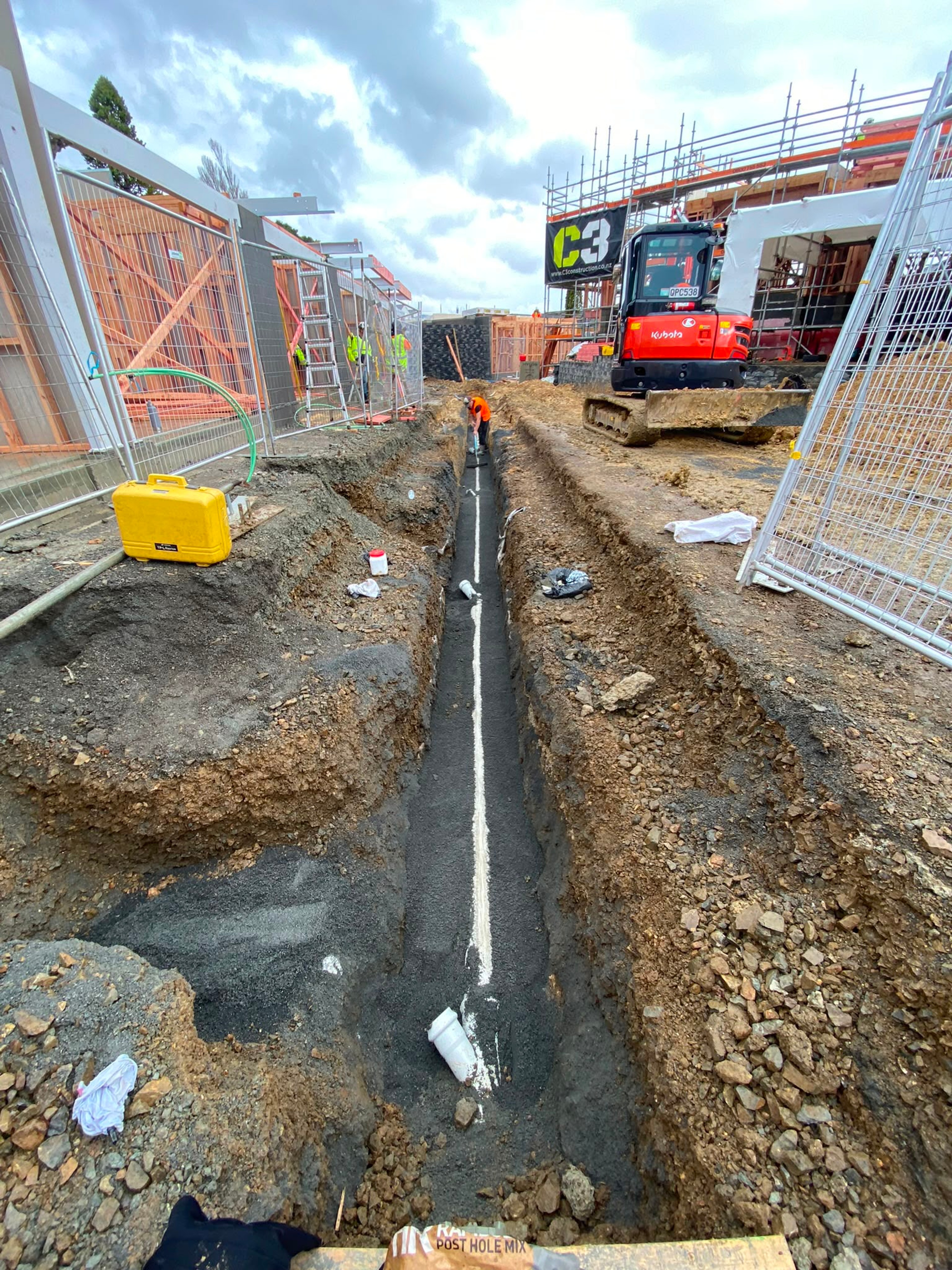 Long service trench running alongside a fenced commercial site