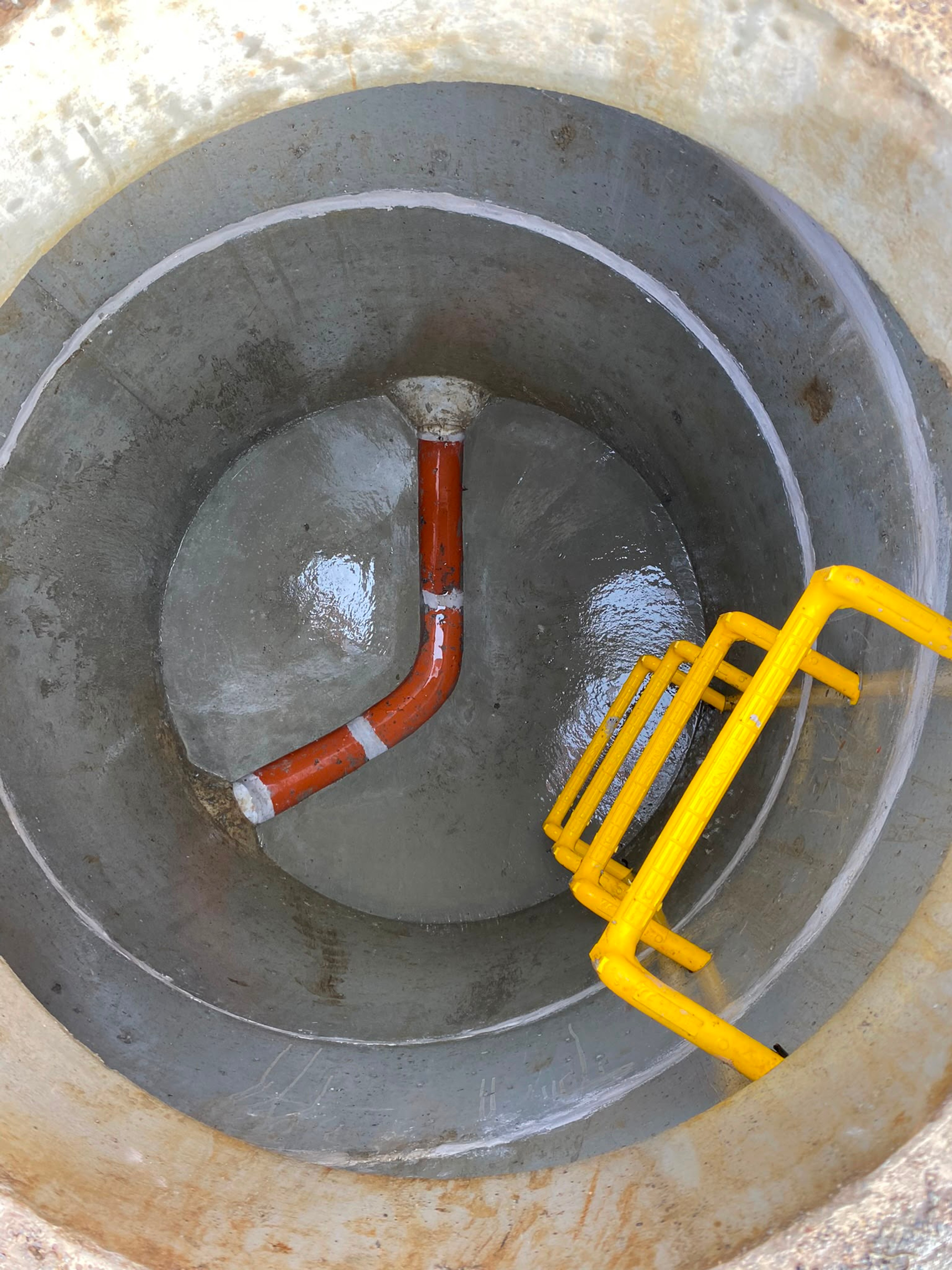 Looking into a manhole at the benched channel and step irons