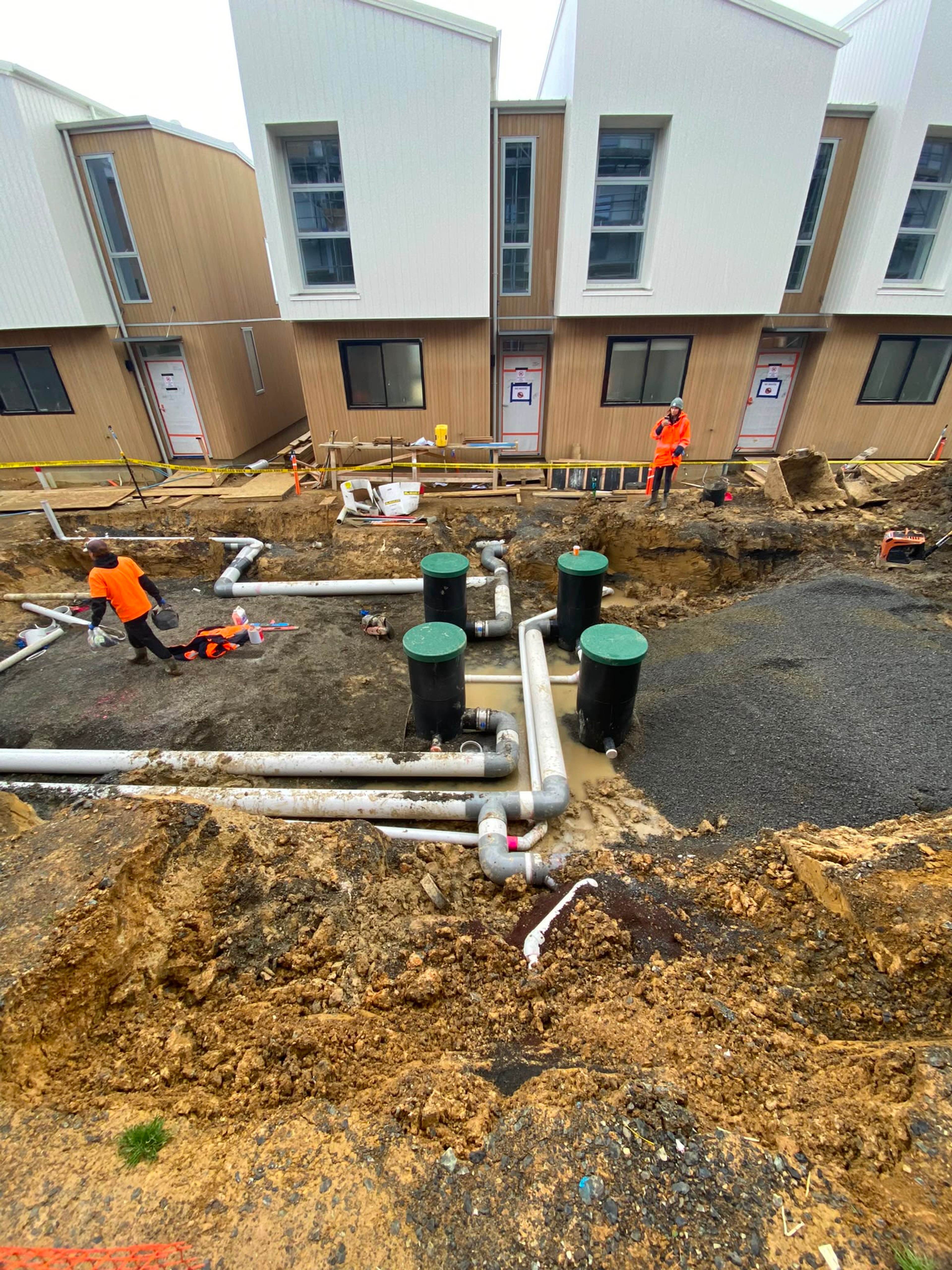 Stormwater pipe runs and inspection chambers set out beside a commercial building