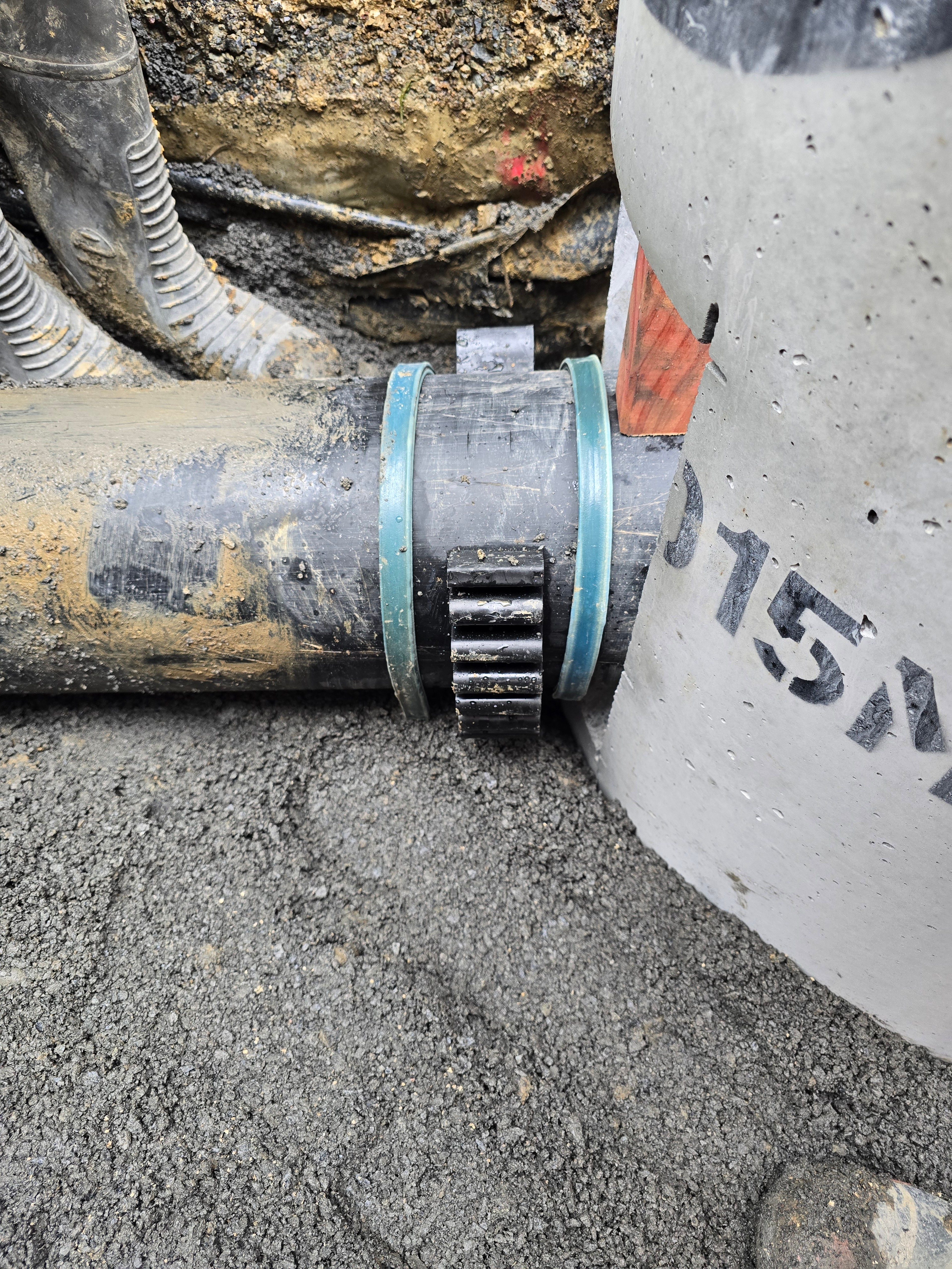 Rubber ring joint sealing a PVC pipe into a concrete chamber