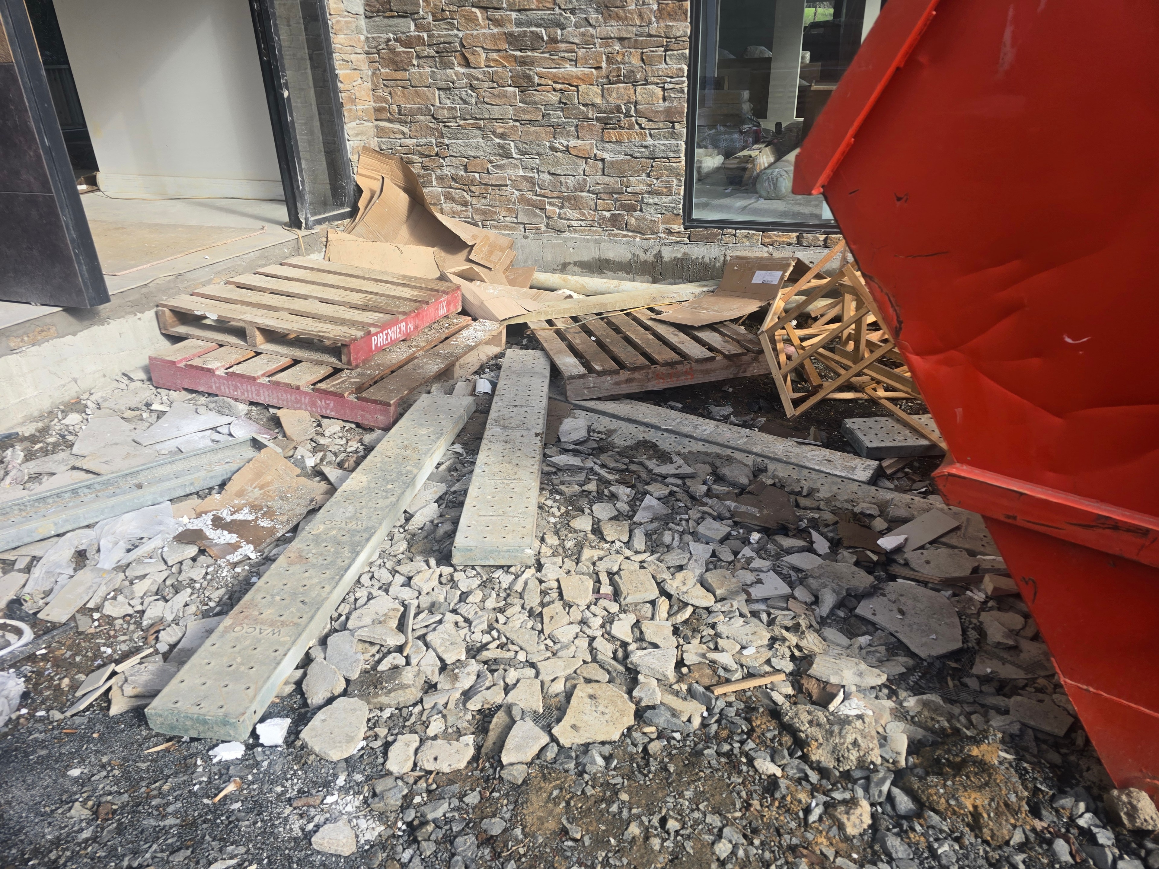 Broken-out concrete and building debris loaded into a skip during site clearance